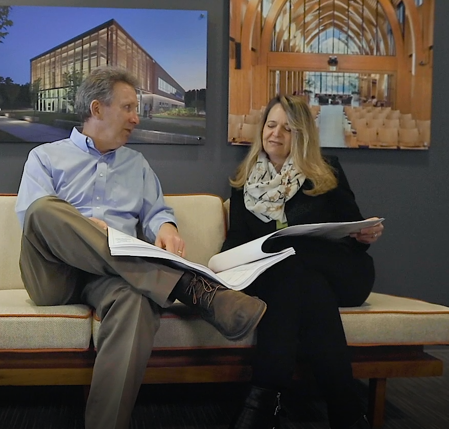 Bobby and Diane sitting on a couch looking at structural engineer designs
