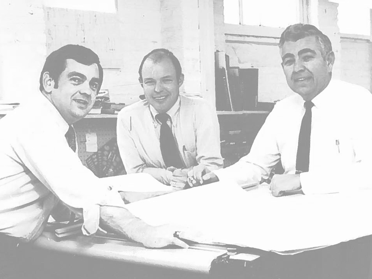 First photo of this Structural Engineering Firm - 3 Men Working at a table wearing shirts and ties